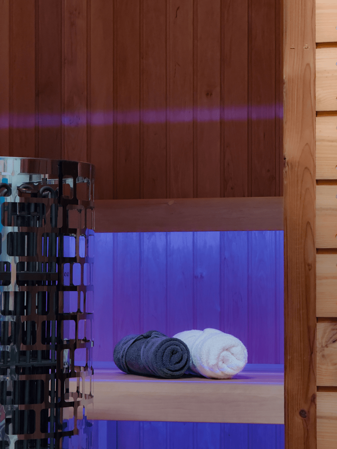 Belső szaunatér hangulatvilágítással, törölközőkkel, kályhával